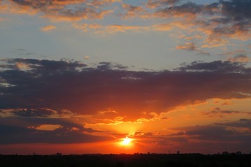 Fototapeta na wymiar Beautiful dark orange sunset with black dramatic clouds in the sky