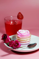 Multilayer sweet coconut fruit jelly with beverage, strawberry and red roses on white plate and pink background and space for write wording for happiness moment. Unhealthy dessert high sugar and fat. 