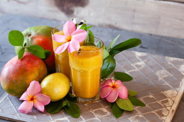 Fresh tropical fruit smoothie mango juice with leaves and fruits