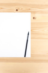 Pencil on white paper list on a wooden desk with copy space