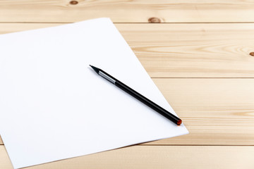 Pencil on white paper list on a wooden desk with copy space.