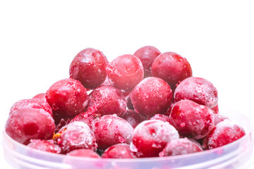  Red fruits is in a round plastic form. Bunch of winter cherries are isolated on a white background. Frozen cherries are in a plastic bucket.
