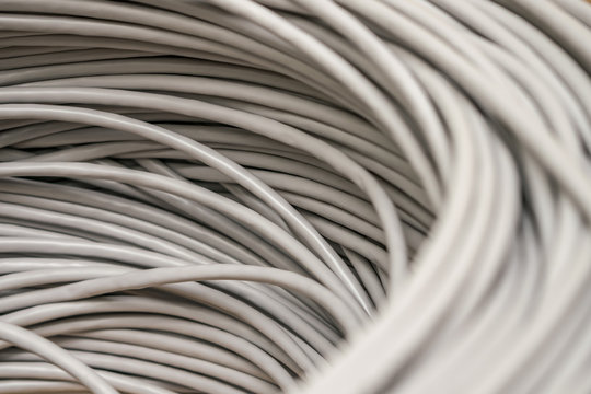 Bunch of gray Unshielded twisted pair cables is a close-up. Abstract technological background texture. The concept of wired Internet communications.