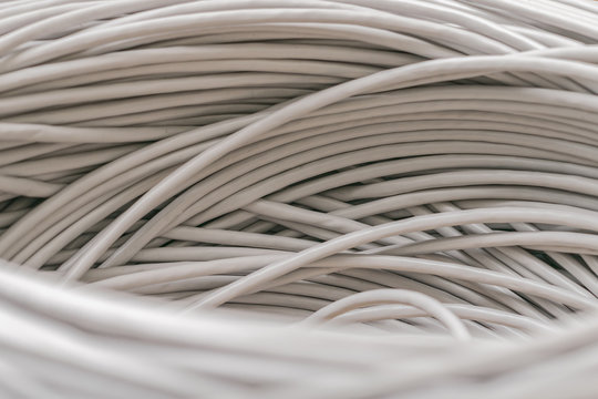 Bunch of gray Unshielded twisted pair cables is a close-up. Abstract technological background texture. The concept of wired Internet communications.