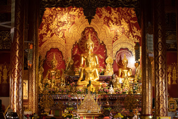 Fototapeta na wymiar Interior of a Buddhist temple with many golden statues, Chiang Mai, Thailand