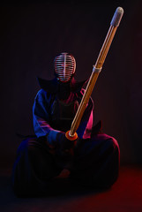 Close up. Kendo fighter wearing in an armor, traditional kimono, helmet, sitting, practicing...