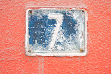 Lucky 7, number seven, grungy blue plate on pink background.