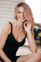 Portrait of beautiful young blonde woman with makeup in black dress