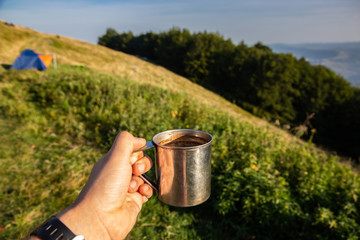 tourist mug in the mountains with coffee. Holidays in the Carpathian mountains.