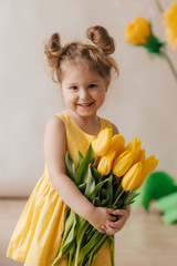 Portrait of beautiful little girl with yellow flowers