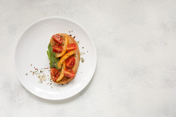 Italian bruschetta with tomatoes on a white plate against white background. View from above