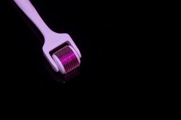 Mezoroller, dermaroller, mesotherapy skin tool. A mesoroller with a white handle and a pink rabbit on a dark mirror background. Roller set with microscopic needles. Stimulate collagen production.