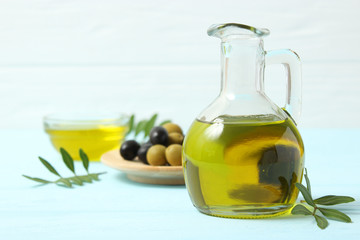 olive oil, green leaves and olives on the table.