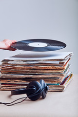 Woman taking vinyl from stack of vinyl records