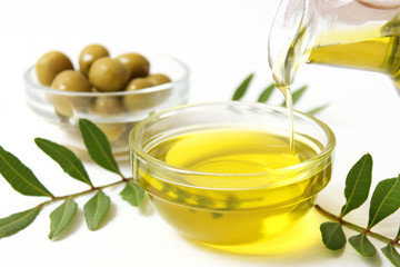 Olive oil, olives and green leaves.
