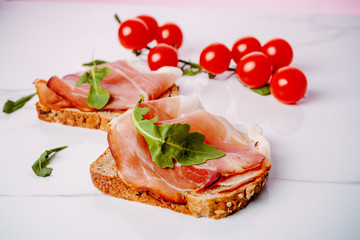 slice of bread with smoked ham and tomato on a white background