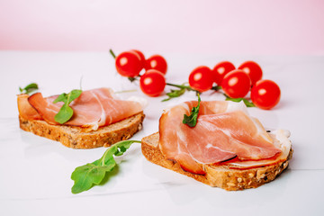slice of bread with smoked ham and tomato on a white background