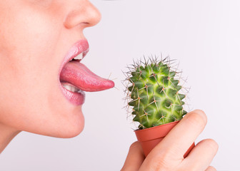Girl licks tongue prickly cactus. Lick the prickly cactus with your tongue. Cactus needles in the...