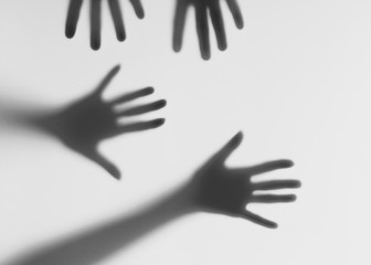 Silhouettes of male and female hands. Conceptual scene. Male and female hands behind a frosted glass.