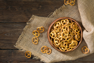 Pretzels in a wooden bowl on a wooden background. Rustic style