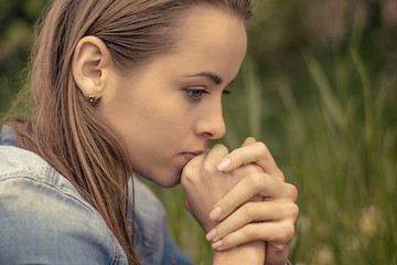 Emotion concept. A young unhappy woman holds her hands in front of her face. Burnout and depression.