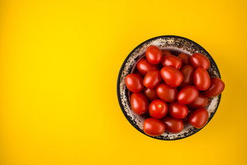 Flat lay with red tomatoes on yellow background
