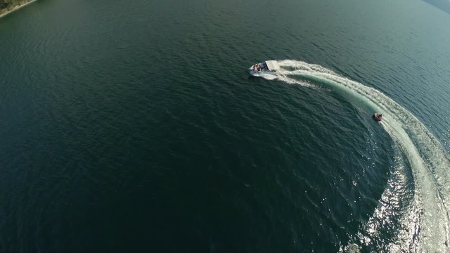 Speed Boat Pulling Tube on Beautiful Turquoise Water in Summer Activity Aerial