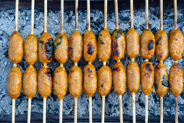 Grilled Thai sausage at street food market in Thailand. Traditional Thai sausage with pork and rice, delicious street food.