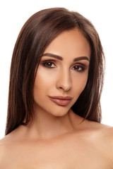 Fototapeta premium Close up portrait of a brunette nude model girl with professional evening make-up and plump lips, posing isolated on white background.