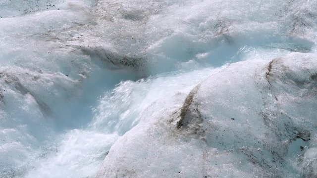 Close-up of glacial water run-off flowing through the ice fields as it melts in the warm summer sun.