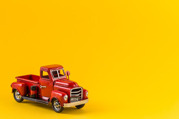 Red toy truck on bright yellow background