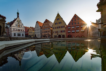 Fototapeta na wymiar Häuserzeile am Marktplatz der Altstadt von Rothenburg ob der Tauber in Mittelfranken, Bayern, Deutschland spiegelt sich im Wasser 