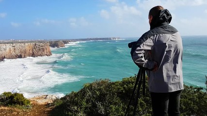 A videographer photographer is shooting a storm in the ocean. Portugal, Sagres.