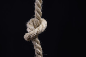 Rope with knot on black background