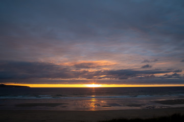 Obraz premium Sunset over the beach in Cornwall with reflections in the sand