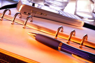 A Pen Lies On An Open Personal Organiser Ready To Take Notes. A Smartphone Can Be Seen In The...