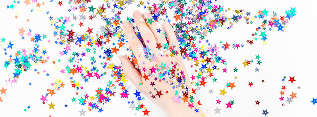 Woman hand with festive color star confetti