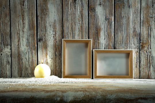 frames on wooden wall and and burning candle