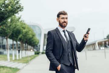 Handsome man in suit using smartphone	