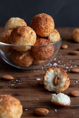Coconut cookies with almond in a glass bowl on a wooden table.