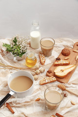 Obraz na płótnie Canvas Coffee with milk, cookies, cinnamon and fruits on the tablecloth.