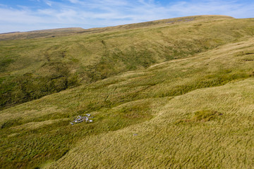 Aerial drone view of an old aircraft crash site on a Welsh hillside in the Brecon Beacons