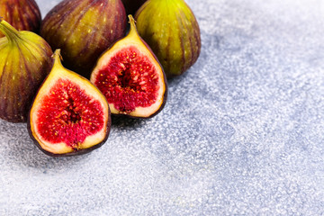 Whole and halved ripe organic delicious figs. Healthy nutritious vegan snack full of fiber and antioxidants, rich on variety of vitamins and minerals. Close up, copy space, top view, background.