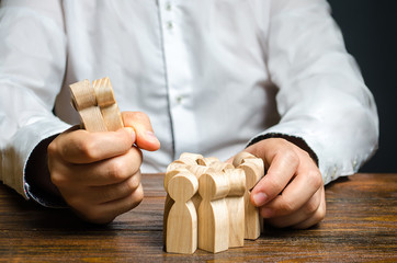 A man grabs a figurine of people from the crowd. Hiring employees. Market Segmentation and Niche...