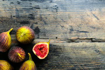 Whole and halved ripe organic delicious figs. Healthy nutritious vegan snack full of fiber and antioxidants, rich on variety of vitamins and minerals. Close up, copy space, top view, background.