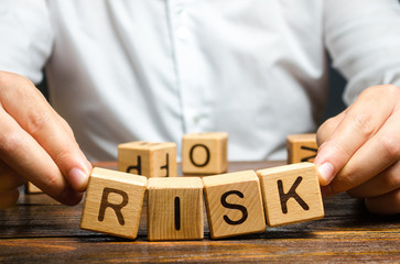 The man carelessly raises the word Risk. High risks in business, fragile balance and insecurity....