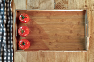 Red vegetables and wooden tray on the table. Empty, copy space for text, products or decoration.