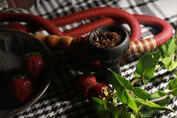 bowl with tobacco for hookah. berries on a black background