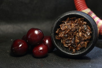 bowl with tobacco for hookah. fruits on a black background