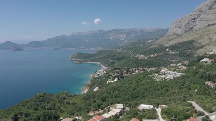 Drone flies above the coastline of the Adriatic sea, southern Montenegro, in a sunny summer day. Water in the sea is turquoise, clean and clear